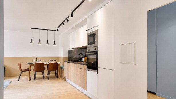 A modern kitchen with a dining area, featuring a built-in oven, microwave, and a dining table with chairs.