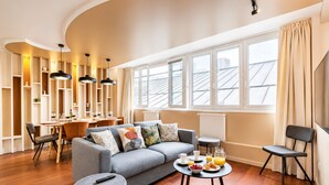 A modern living room with a sofa, coffee table, and dining area. - TBS 87 - Fabulous apartment in Paris (Paris)