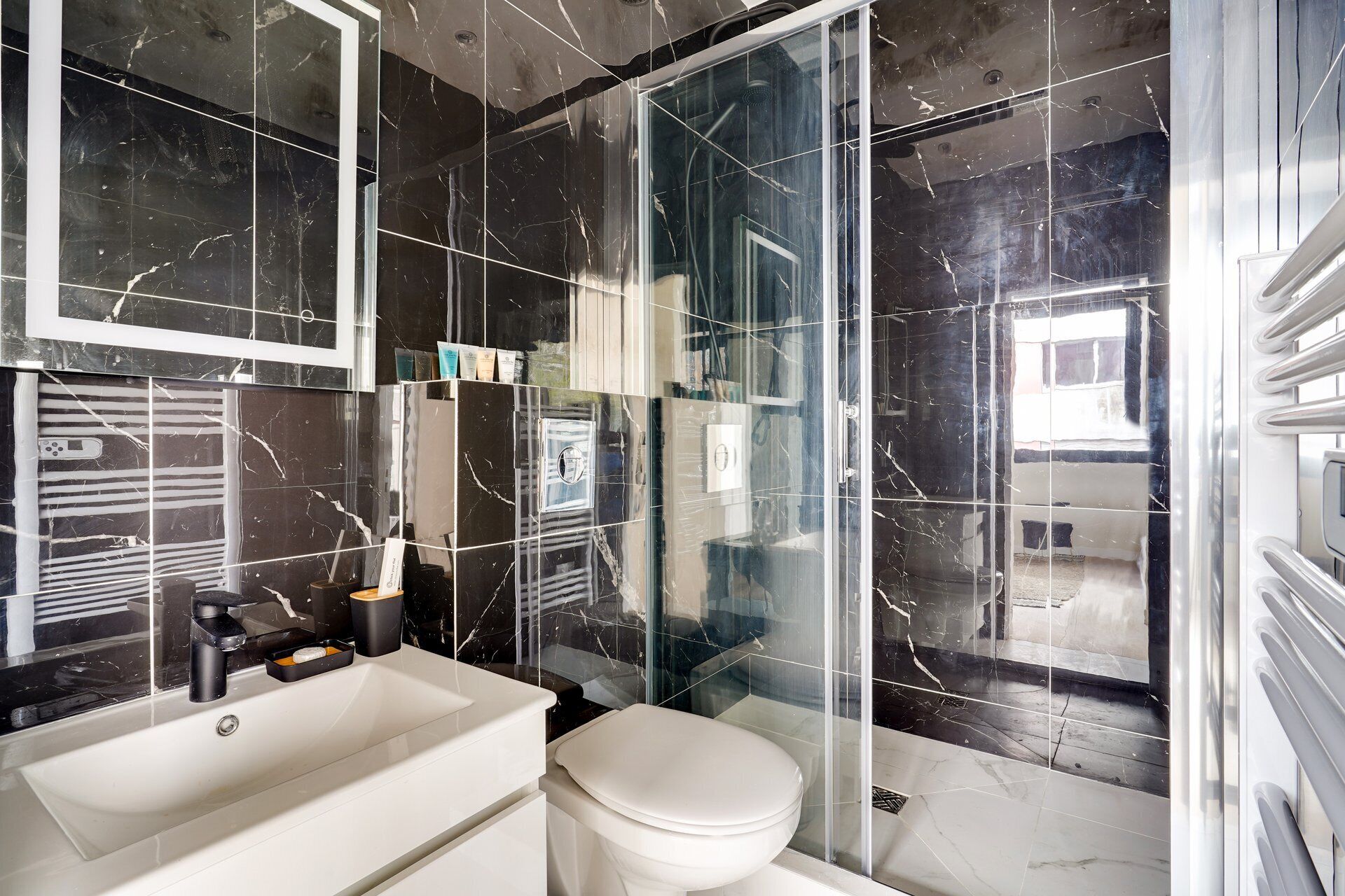 Ein Badezimmer mit Waschbecken, Toilette und einer Duschkabine aus Glas.