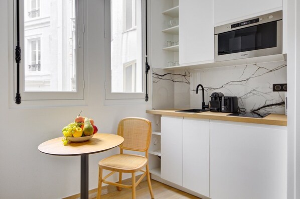 Enjoy a meal at the kitchen table near the window, where a bowl of fresh fruit is always within reach.