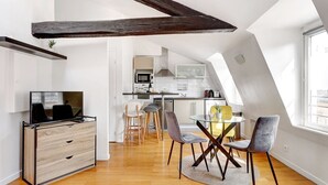 A modern loft apartment with a dining area, kitchen, and living space. - TBS 239 - Nice apartment in Moulin Rouge area (Paris)