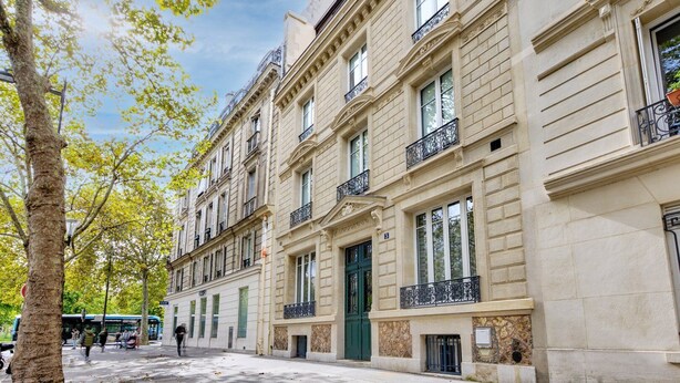 A multi-story building with a classic architectural style, featuring symmetrical windows and ornate balconies.