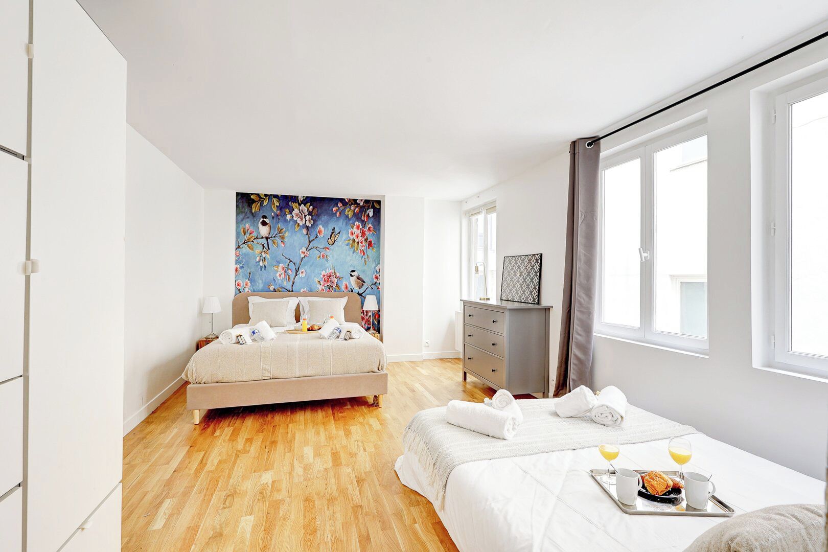 Un dormitorio moderno con una cama grande, un aparador y un cuadro en la pared.