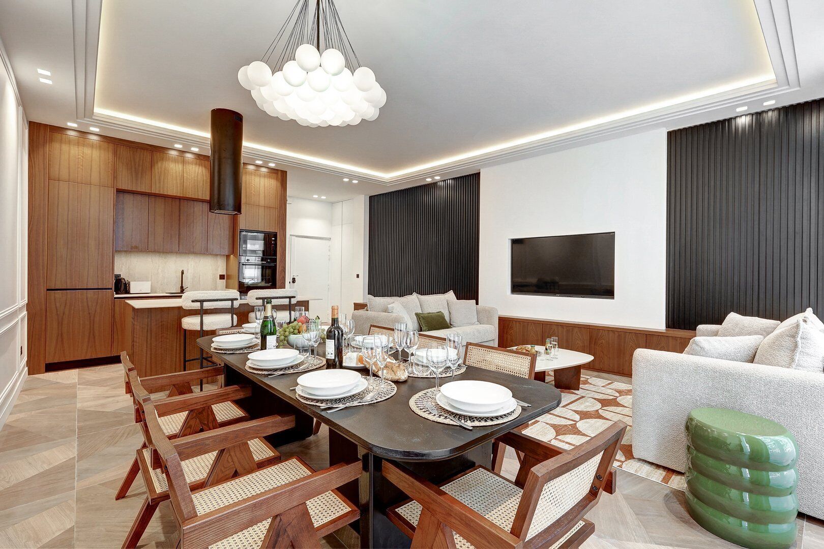 Un comedor moderno con una mesa larga dispuesta para seis comensales, rodeada de sillas de madera con asientos de mimbre.