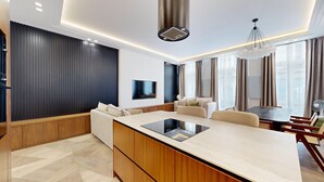 Una sala de estar moderna con una isla central, un comedor y un gran ventanal con cortinas.