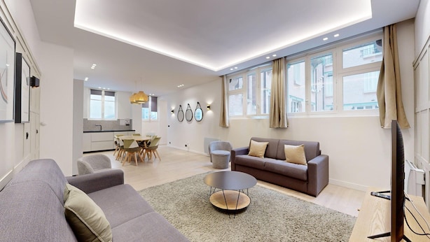 A modern living room with a sofa, a coffee table, and a dining area with a table and chairs. - TBS 61 - Pretty suite near Roland-Garros stadium (Paris 16 Passy)