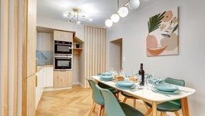 A modern kitchen with built-in appliances and a dining area with a table set for four.