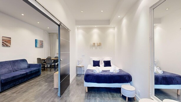 Une chambre d’hôtel moderne équipée d’un lit, d’un canapé, d’un bureau et d’un miroir.