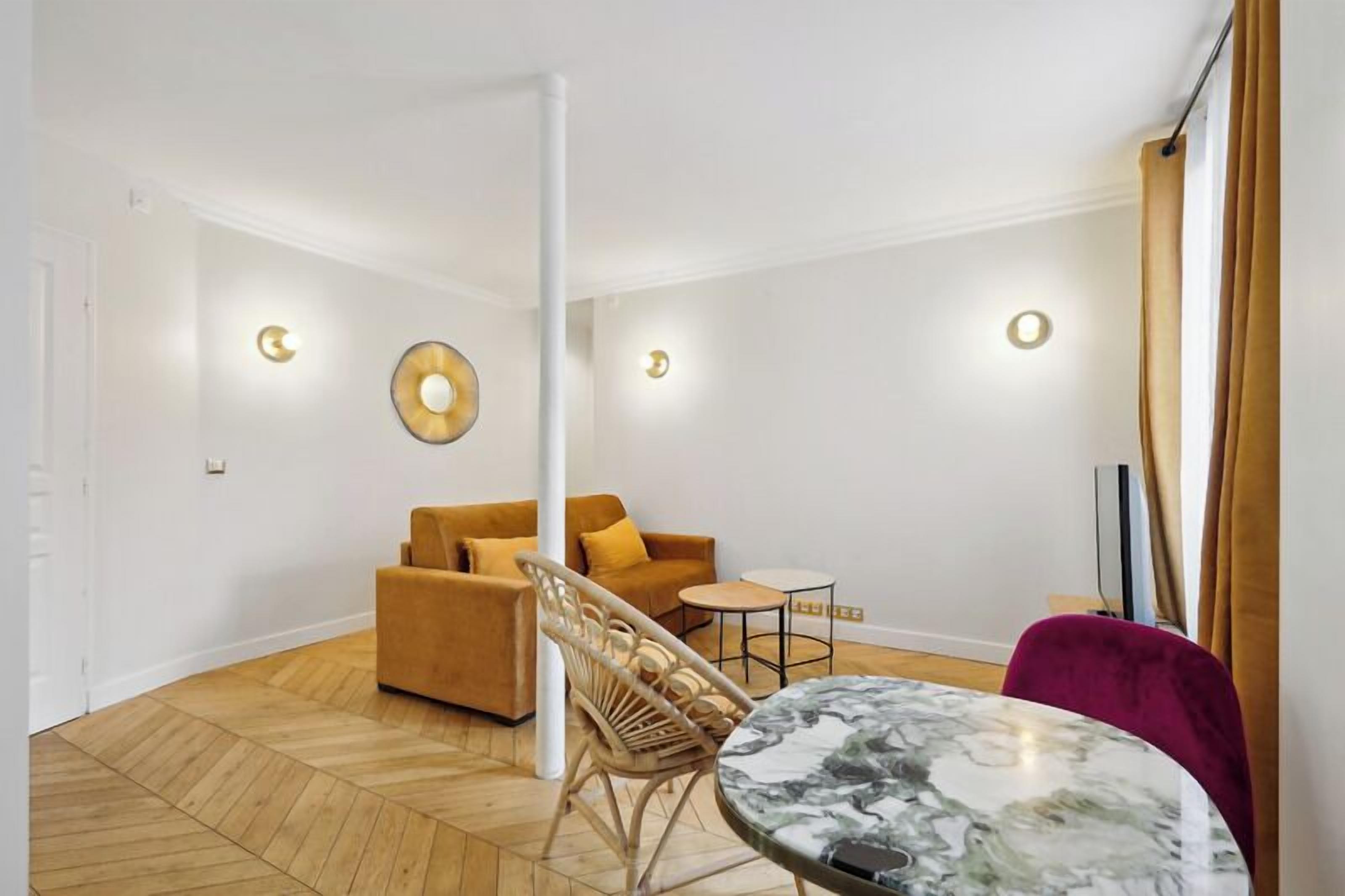 A modern living room with a sofa, a round table, and a chair.
