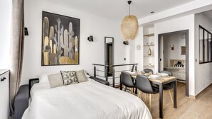 Ein modernes Schlafzimmer mit einem großen Bett, einem Essbereich und einer Wohnfläche.