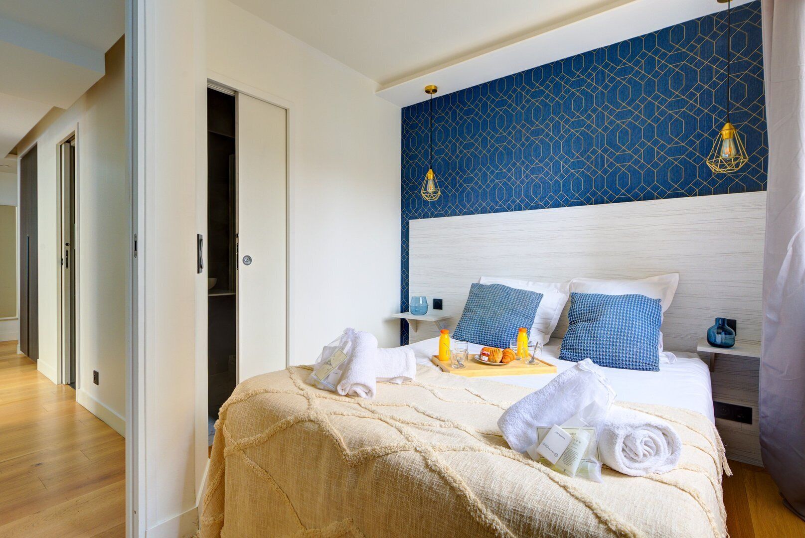 A hotel room with a bed, a bedside table, and a nightstand.