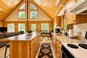 A spacious kitchen with wooden cabinets, a central island, and a dining area.