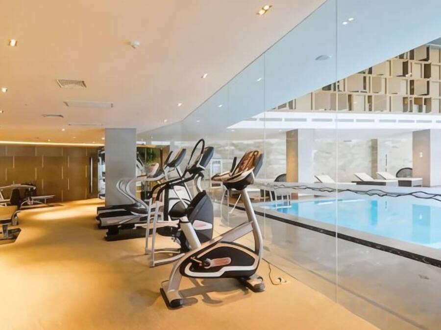 A gym with treadmills and a pool area.