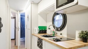 Une cuisine compacte équipée d’un four à micro-ondes, d’un évier et d’une petite fenêtre.