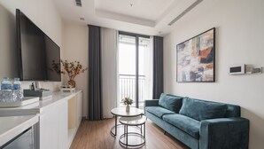 A modern living room with a sofa, a small round table, and a TV.
