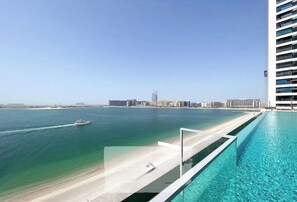 Relax by the infinity pool overlooking the serene beachfront.