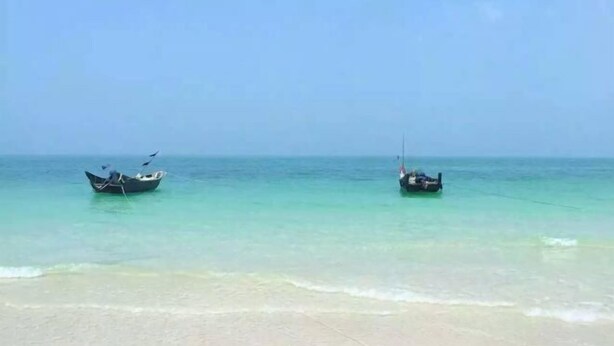 A beach with two boats anchored in calm waters. - Weizhou Island Sea and Tianzhilian Wangxi Inn (Dishui Danping Branch) (Beihai)