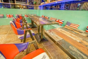 Un comedor con una larga mesa de madera y varias sillas, algunas con banderas.