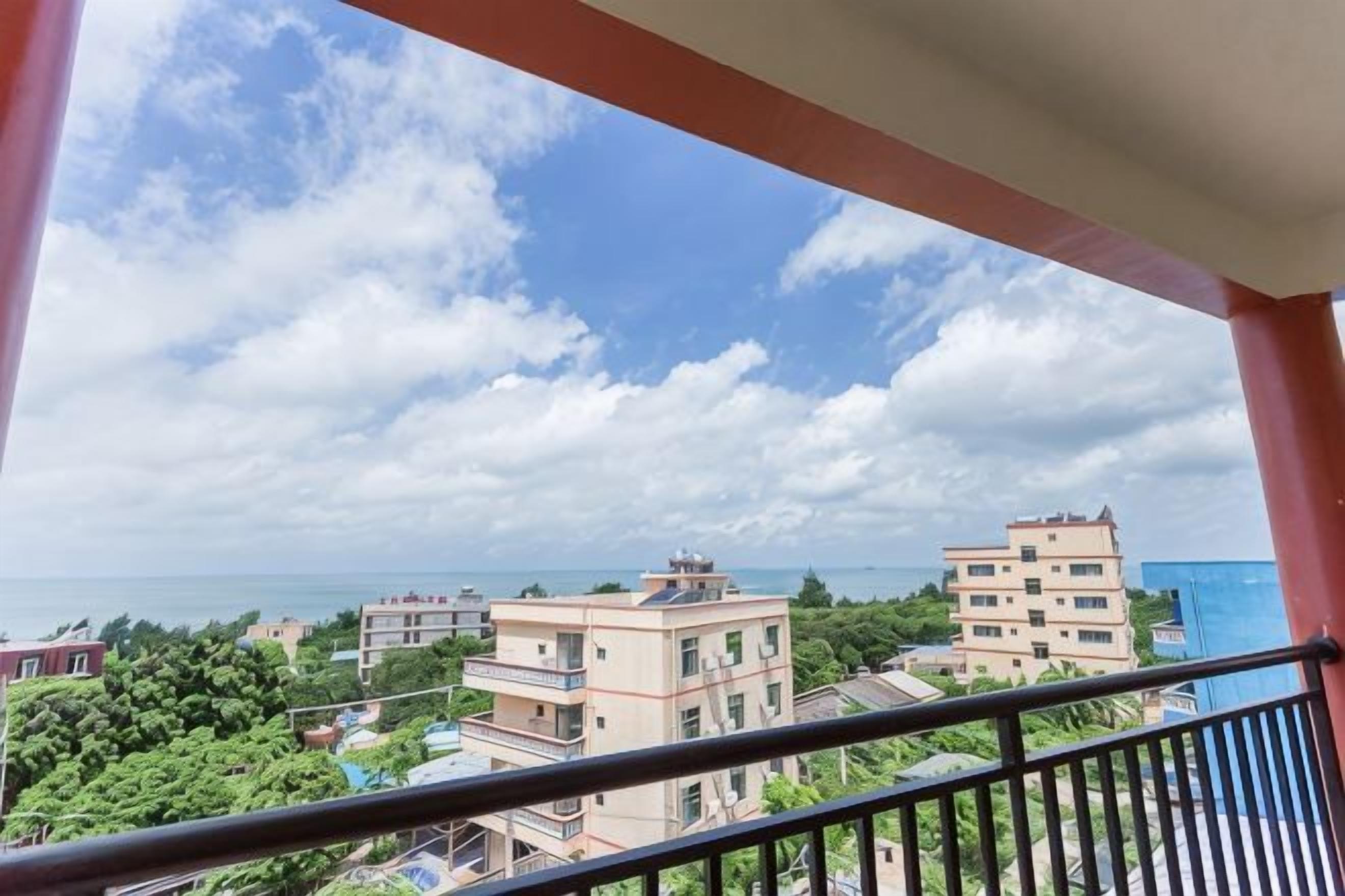 A balcony with a view of buildings and a body of water.