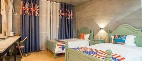 A room with two beds, a desk, and a chair.