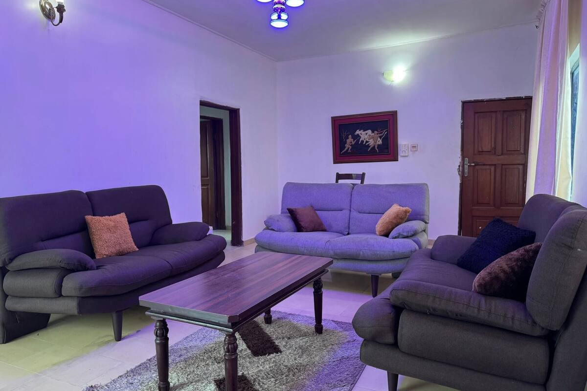 A living room with two sofas, a coffee table, and a ceiling light fixture.
