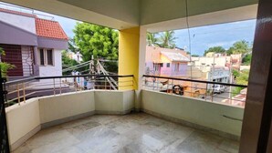 Ein Eckzimmer mit Blick auf umliegende Gebäude und einem Balkon mit Metallgeländer.