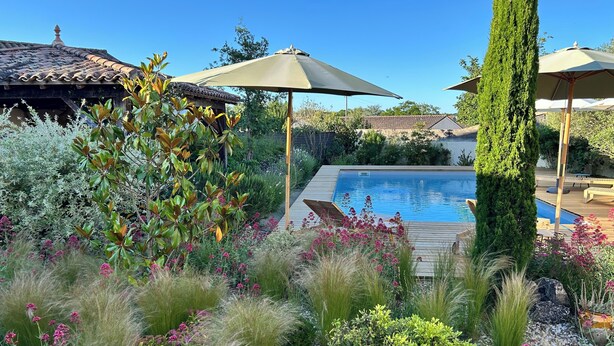A swimming pool surrounded by lush greenery and outdoor furniture. - La Bohème: Gîte with swimming pool 20 minutes from Saint-Emilion. Dogs welcome. (Galgon)