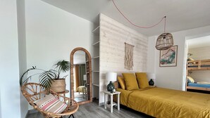 A modern bedroom with a bed, a rocking chair, a mirror, a bedside table, and a hanging light fixture. - La Bohème: Gîte with swimming pool 20 minutes from Saint-Emilion. Dogs welcome. (Galgon)