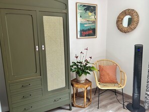 Relax in this stylish room with a vintage wardrobe, wicker chair, and a small table.