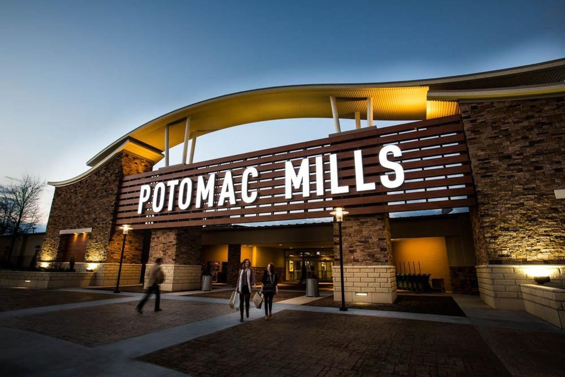 Un edificio con un letrero que dice 'POTOMAC MILLS' al anochecer.