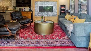 Een gezellige woonkamer met een open haard, een televisie en een comfortabele zithoek.