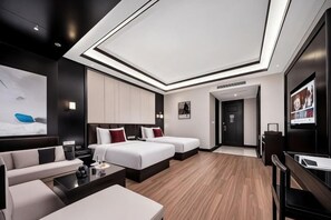 Une chambre d’hôtel moderne équipée d’un grand lit, d’un canapé, d’un bureau et d’une télévision.