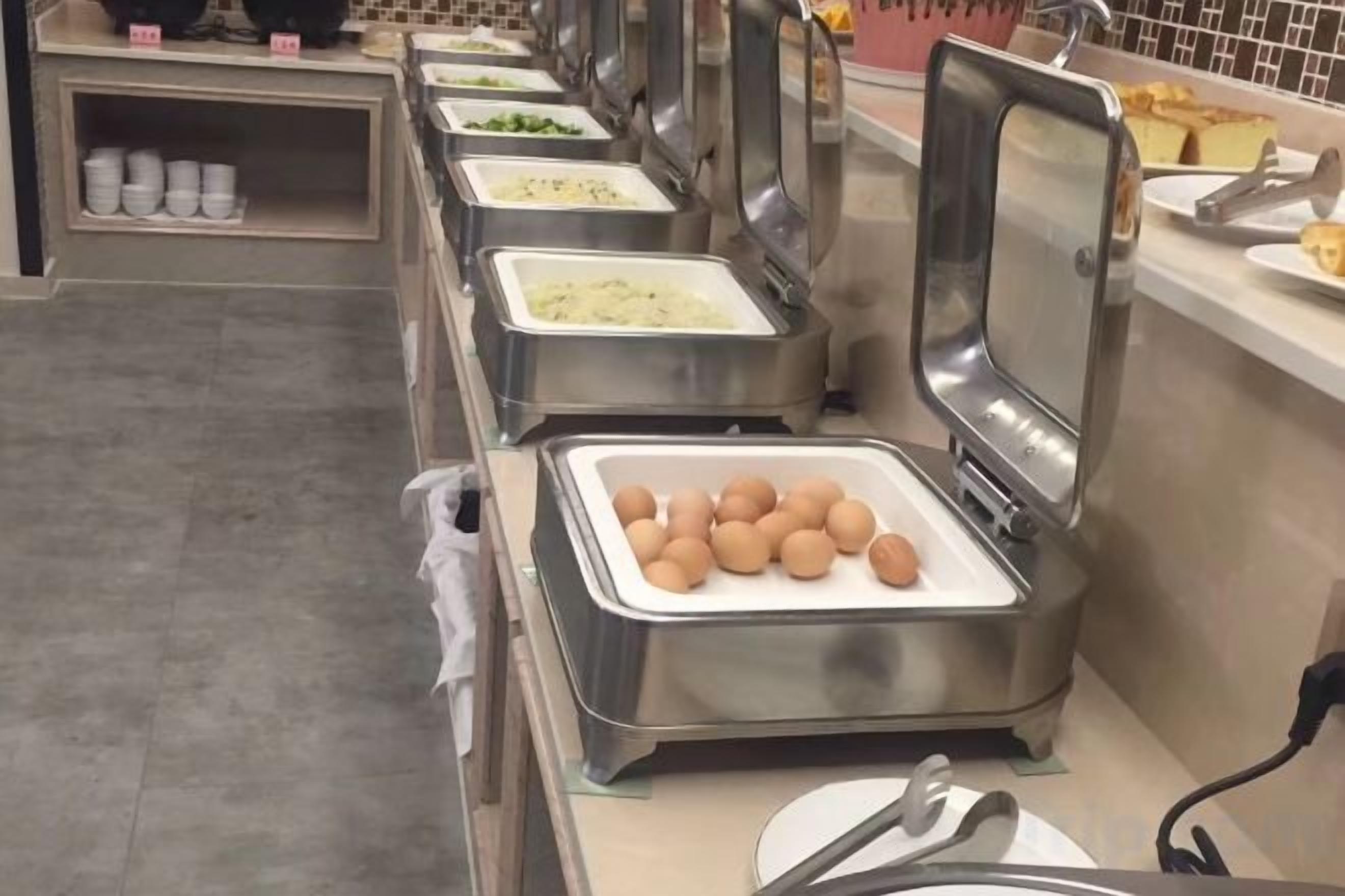 A buffet setup with various food containers and a fryer.