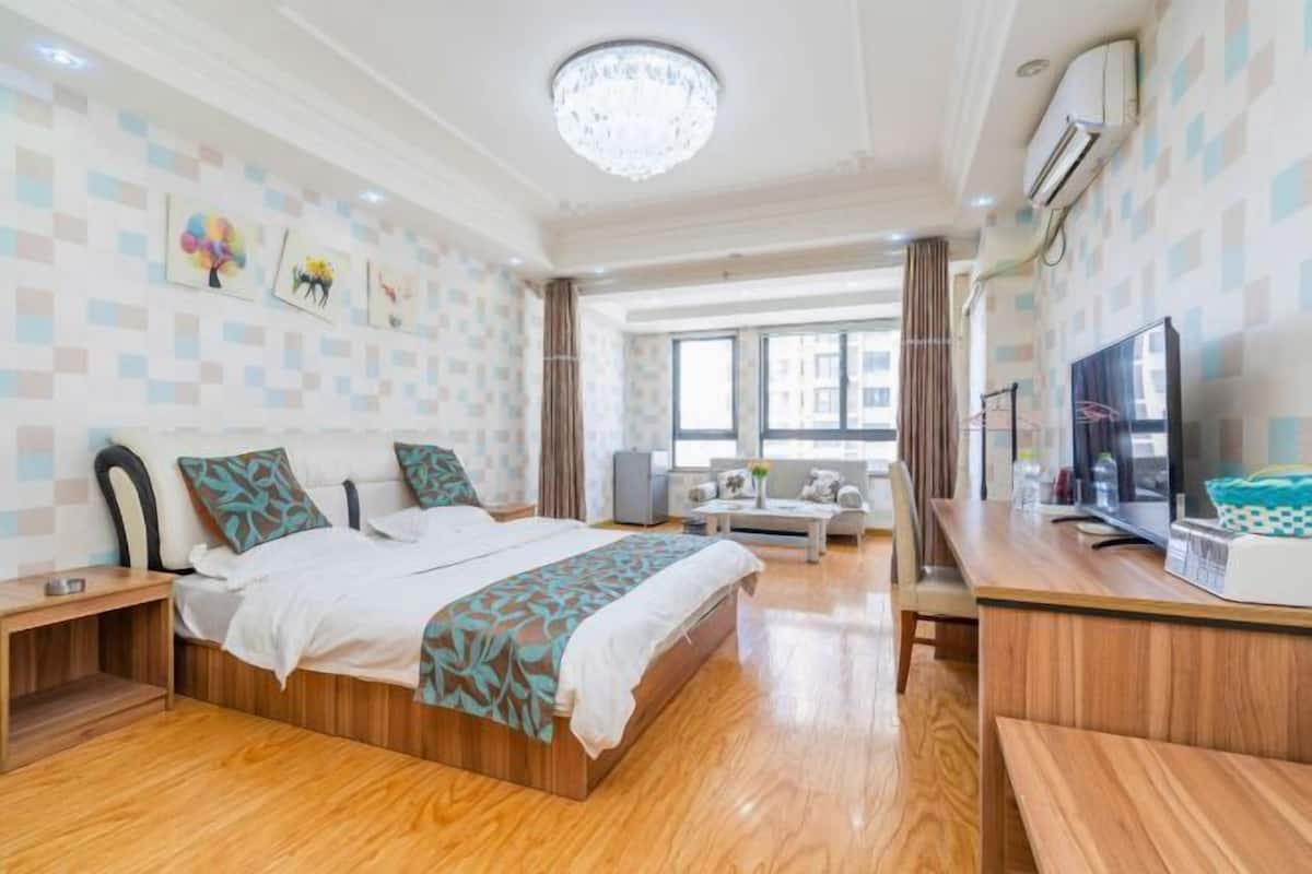 Une chambre d’hôtel moderne, dotée d’un grand lit, d’un bureau, d’une télévision et d’une fenêtre avec des rideaux.