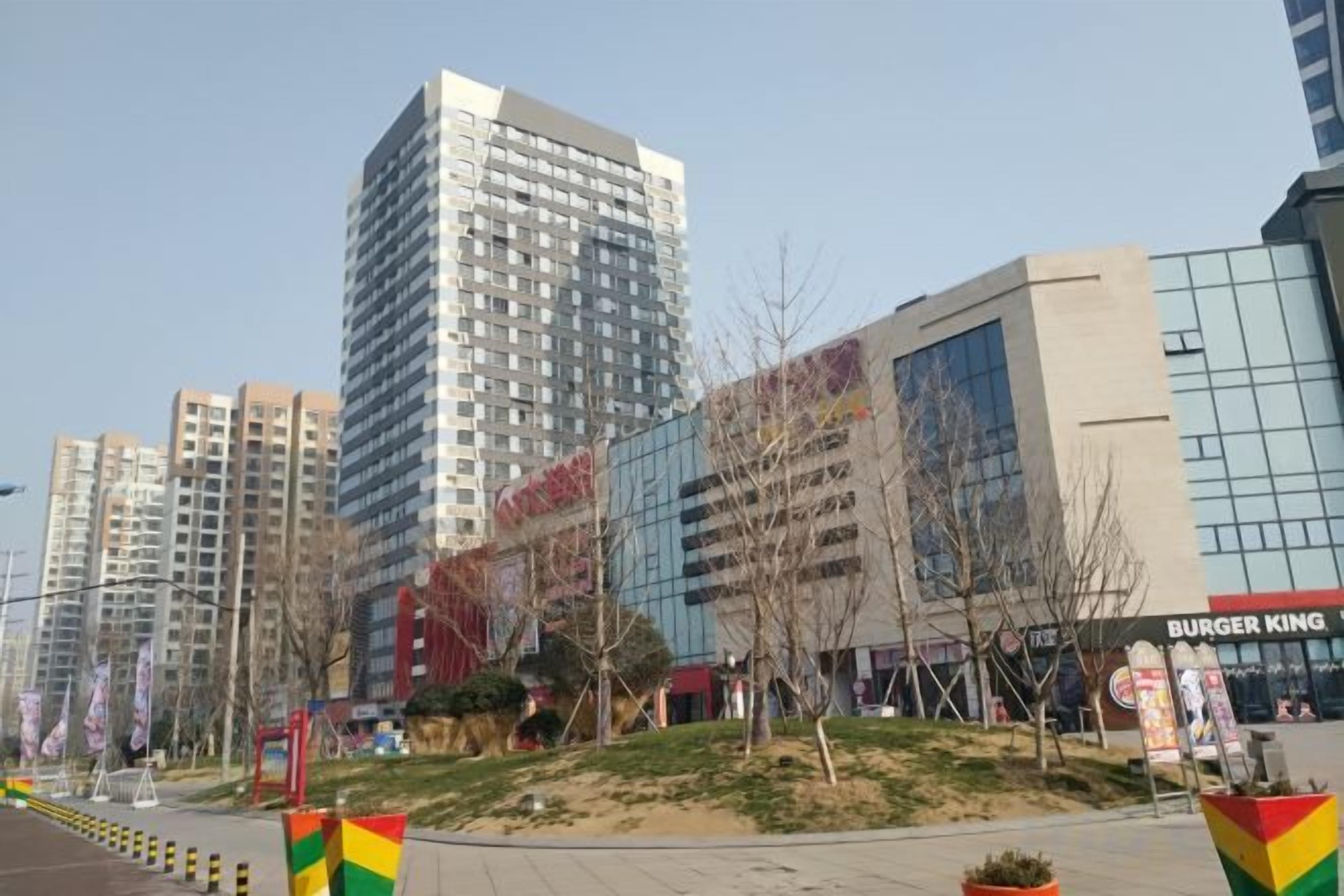 A modern urban area with high-rise buildings, a Burger King restaurant, and a pedestrian walkway.