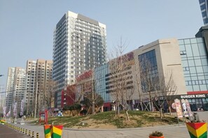 A modern urban area with high-rise buildings, a Burger King restaurant, and a pedestrian walkway. - Jiaozhou Haiyue Apartment Hotel (Jiaozhou)