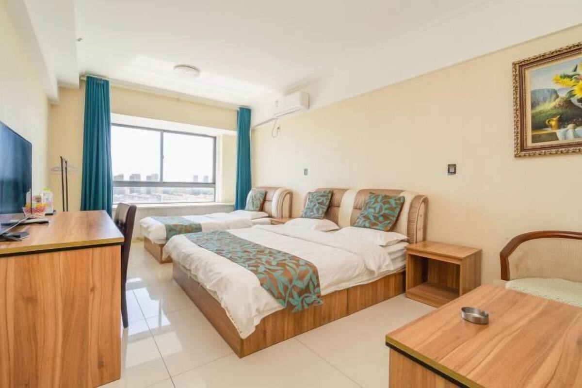 Une chambre d’hôtel avec deux lits, un bureau et une chaise.