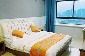 A hotel room with a bed, a nightstand, a window with a view of buildings, and a curtain. - Jiaozhou Haiyue Apartment Hotel (Jiaozhou)