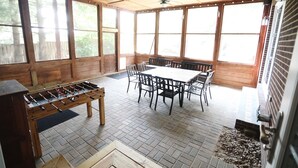 A spacious room with large windows, a wooden table, and chairs. - Purdue Bell Tower views, Central WL location, Walk 2 Purdue (West Lafayette)
