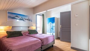 A bedroom with two beds, a large window with a mountain view, and a door leading to another room. - 100m from ski slopes, 3rd floor, swimming pool, sauna, hammam, balcony, fireplace or stove, tv (Val Thorens)