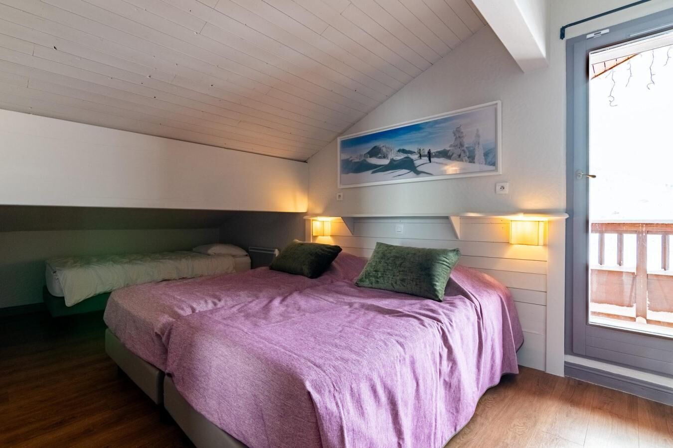 Ein Schlafzimmer mit einem Bett, zwei Nachttischen, einem Gemälde und einem Fenster.
