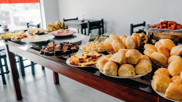 Een buffet met diverse gerechten, waaronder brood, gebak en een vleesgerecht.