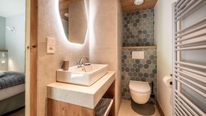 Une salle de bain moderne avec un meuble-lavabo en bois, un évier et des toilettes.