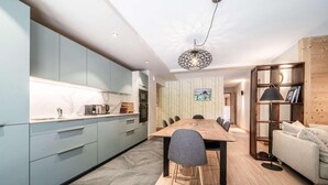 Una cucina moderna con mobili azzurri, un tavolo da pranzo in legno e un divano grigio.