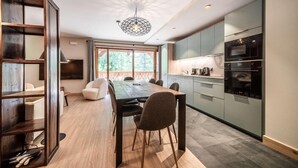 Una cucina moderna con zona pranzo, elettrodomestici integrati e un'ampia finestra.