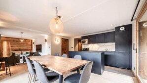 A modern kitchen with dark cabinetry, a central island, and a microwave. - 1st floor, balcony, parking, tv, ski locker, 93m², Morzine (Morzine)