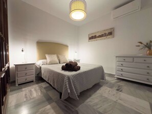 A neatly arranged bedroom with a bed, bedside tables, a dresser, and a hanging light fixture. - Spacious Apartment, Seneca 1A next to the Center. (Málaga)