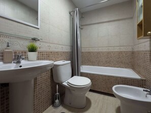 A bathroom with a toilet, sink, and bathtub. - Spacious Apartment, Seneca 1A next to the Center. (Málaga)