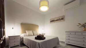 A neatly arranged bedroom with a bed, bedside tables, a dresser, and a hanging light fixture. - Spacious Apartment, Seneca 1A next to the Center. (Málaga)