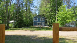A two-story blue house with a porch, surrounded by trees and a fenced yard. - Ruthie's Cottage
Charming 3-bedroom cottage with WiFi in Barbeau. 20 m Sault, Mi (Barbeau)